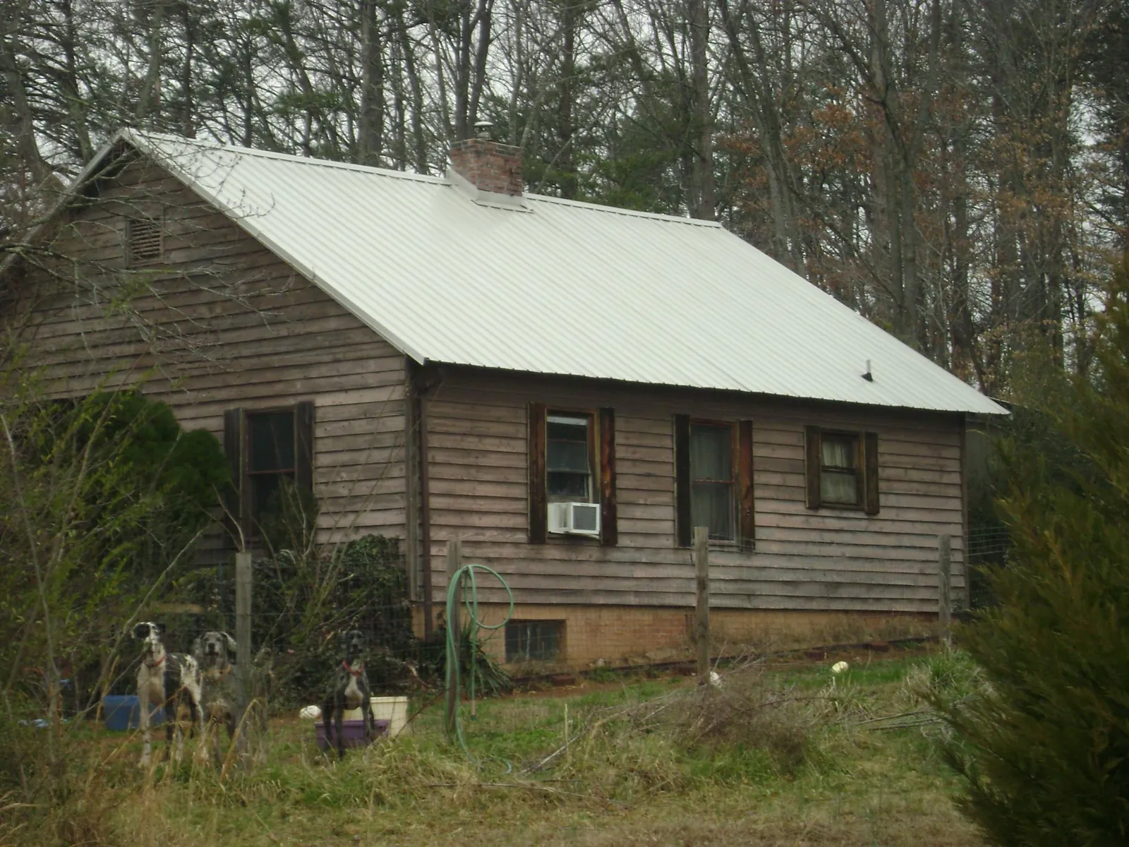 White metal roof on an old wood sided farmhouse, from a Metal Roof Installation job in Odessa